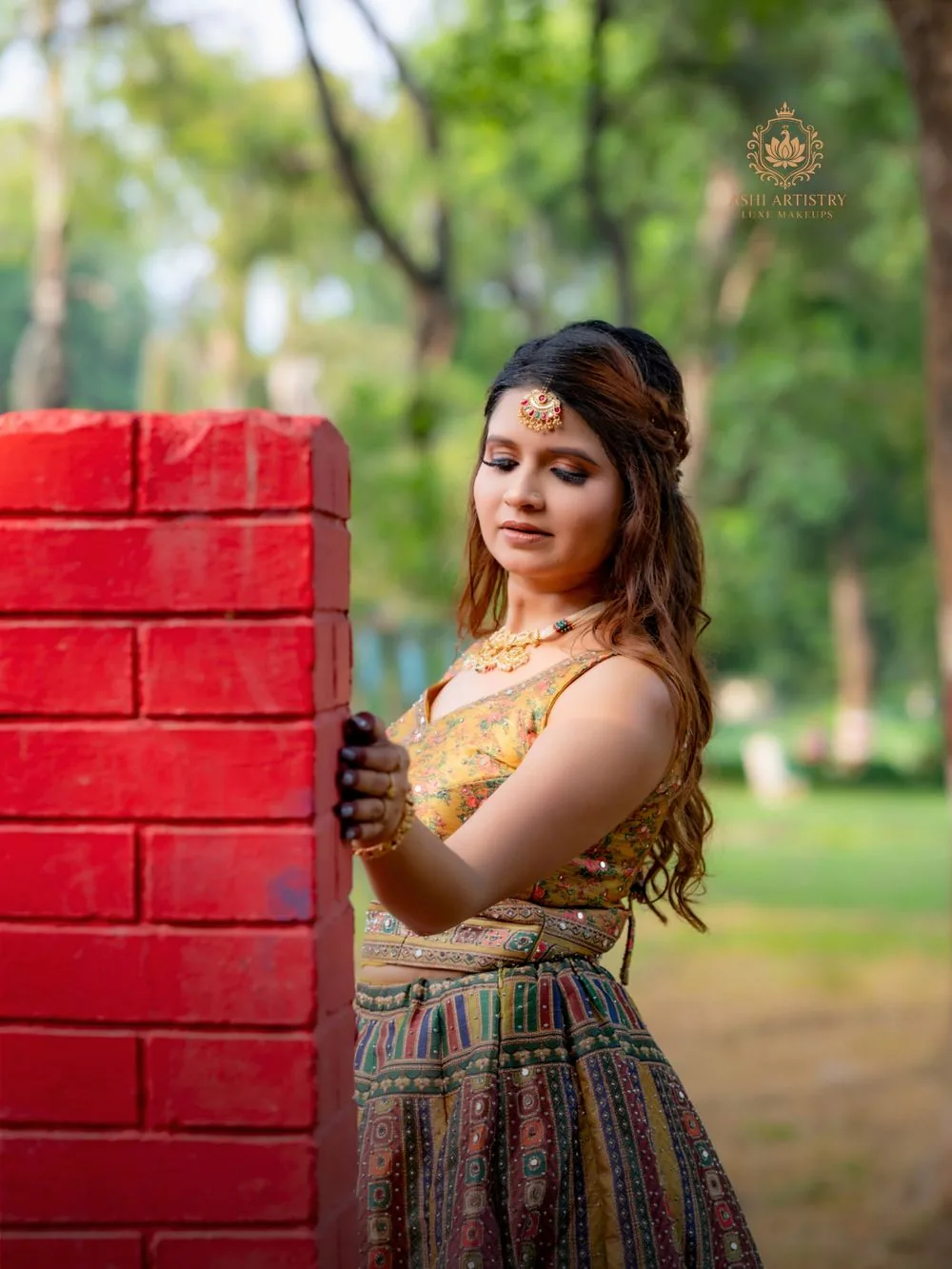 Haldi-ready glam look in a yellow-green lehenga against a brick wall